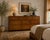 An exceptional 1970s John Widdicomb Campaign lowboy dresser crafted in richly figured burlwood veneers with elegant...