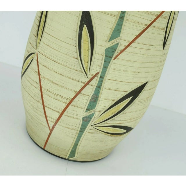 A large vase by Josef Duck, Hillscheid from the 50s. Multicolored floral engraved decor on pastel yellow background with...