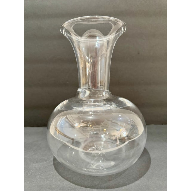 Elegant handblown clear glass decanter featuring a spherical body, narrow collar, and wide flared trumpet neck. Pontil...