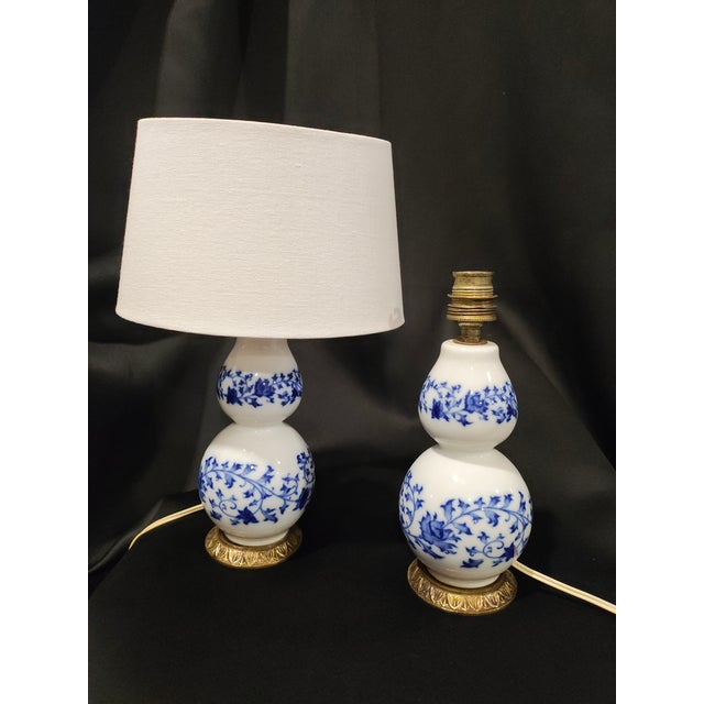 A stylish pair of mid-20th century chinoiserie porcelain table lamps, dating to approximately 1950s–1970s. Each lamp...