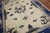 An early 20th century Chinese Peking Dragon motif rug with a spacious open field design on an ivory ground Measures: 7'3''...