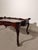 A Rococo Revival coffee table in a rich mahogany-toned finish, featuring elaborate carved decoration throughout. The table...