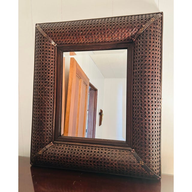 Vintage 80's brown regtangle rattan mirror. 25" tall, 22" wide, 3" deep. Nice beveled mirror.