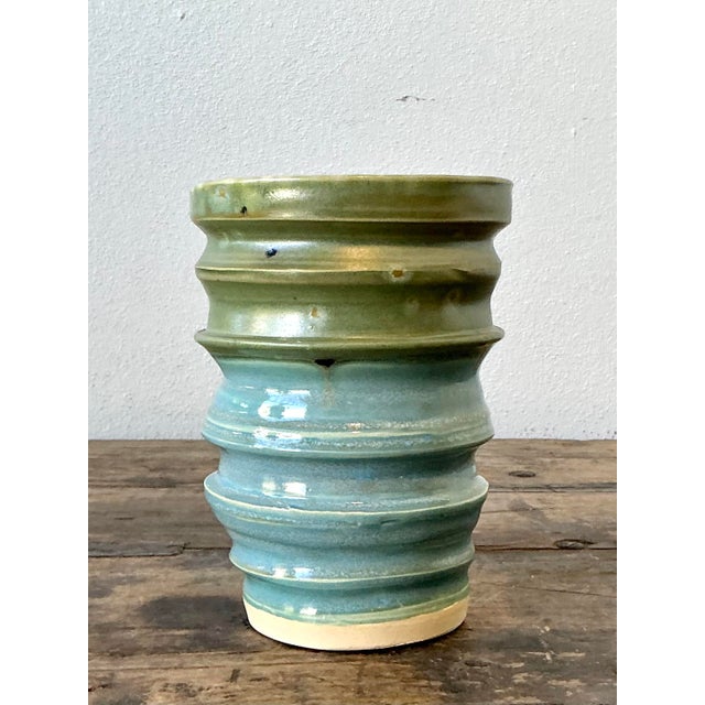 This artisanal studio pottery vase is a masterclass in organic texture and sophisticated color transition. Hand-thrown and...