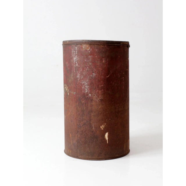 This is an antique metal flour bin circa late 19th century. The large red tin bin features a decorative floral design...