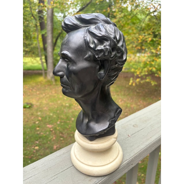 Standing over a foot tall, an imposing bust of Abraham Lincoln, executed in what looks like black basalt on a marble base...