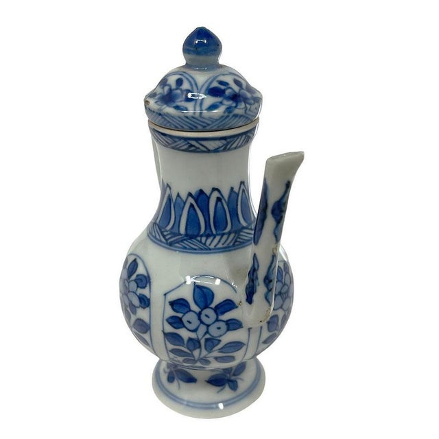 A Blue and White porcelain lidded jug with a long sprout decorated with underglaze white and blue patterns of flowers in...