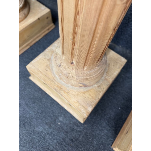 A striking set of four monumental Corinthian style architectural columns crafted in pine with richly carved capitals and...