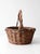 A vintage woven willow basket with a deep, rounded form, high arched handle, and wonderfully irregular twig weave. Natural...