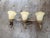 Ornate pair of three-light vanity wall sconces with a bronze-tone finish. Each fixture has three frosted yellow glass...
