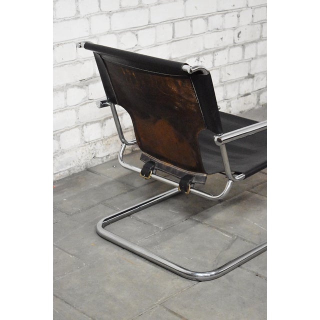 Cantilever armchair manufactured by Arrben, Italy. Made of bend tubular frame and thick sadle leather. with age and usage...