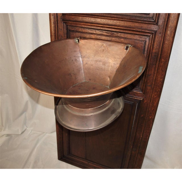 An antique French hammered copper lavabo wall hanging fountain and basin mounted to an old French armoire door. Two-piece...