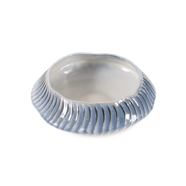 Featuring a smooth glossy white finish accented by a rhythmic wave of soft blue and subtle gold detailing, evoking rolling...