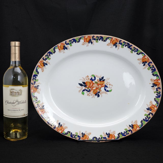 A large heavy oval platter from the late 19th Century with colorful transfers of roses with floral and arabesque...