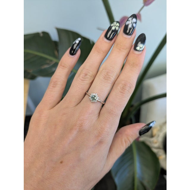 A natural Brazilian alexandrite takes center stage in this solid 14K white gold ring, framed by twelve earth-mined...