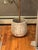 This pot planter brings a touch of vintage charm to your home. It's made from cement and strikes a bowl-like silhouette...