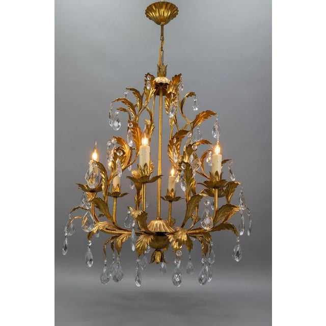 Glamorous 1970s Italian Hollywood Regency chandelier in gilt metal with sparkling crystal glass drops. Six lights, perfect...