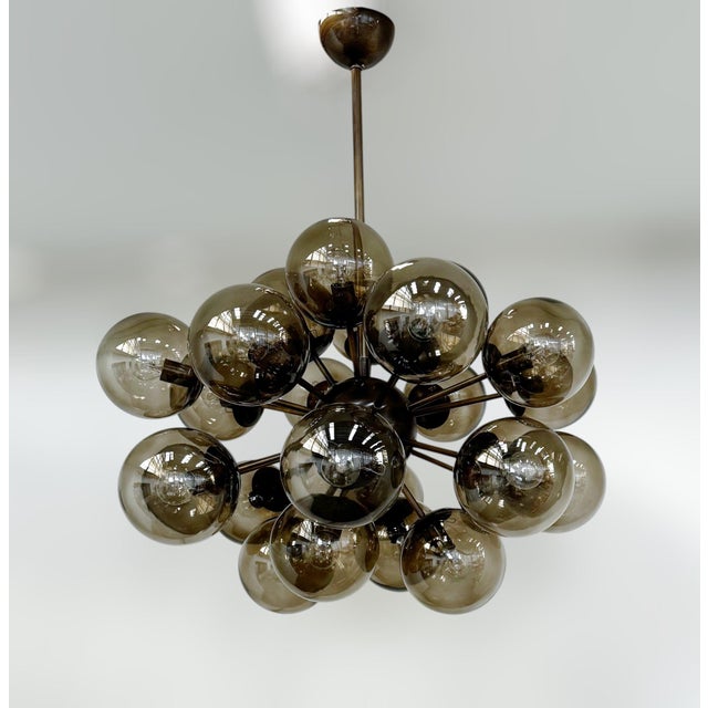 Italian oval shaped sputnik chandelier with 24 smoky Murano glass globes mounted on brass frame in bronze finish / Made in...