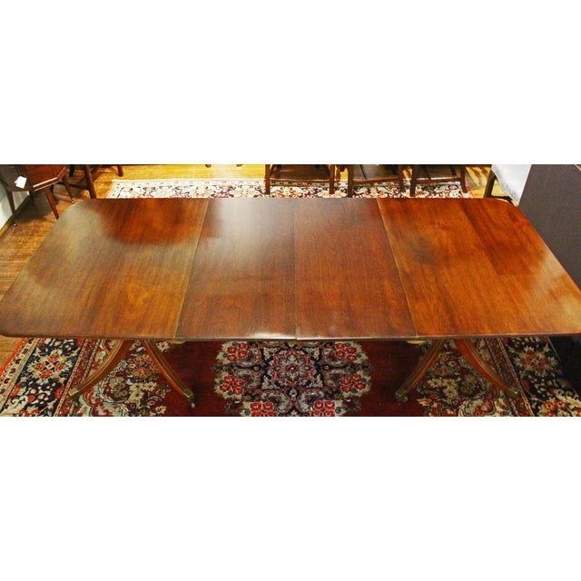 Early 20th century Georgian style double pedestal banquet dining table, English. Mahogany. Reeded edge. Raised on gun-...