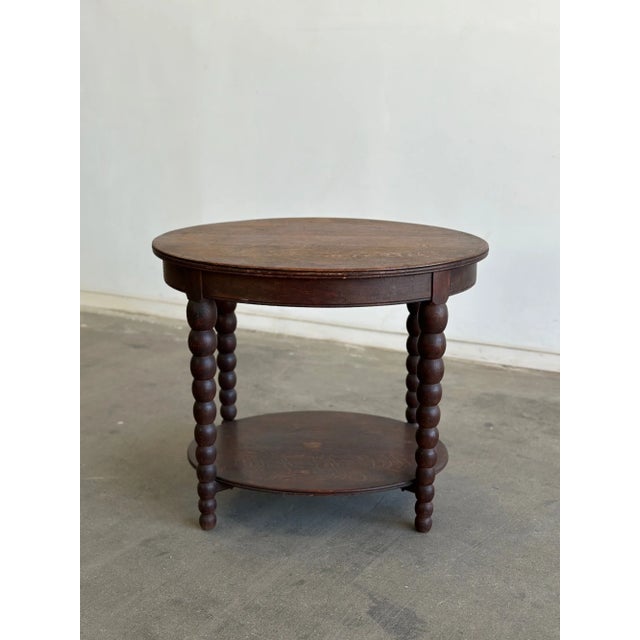 W31 D24.5 H26 A charming vintage side table with a slightly oval rounded top with turned bobbin style legs. This two...