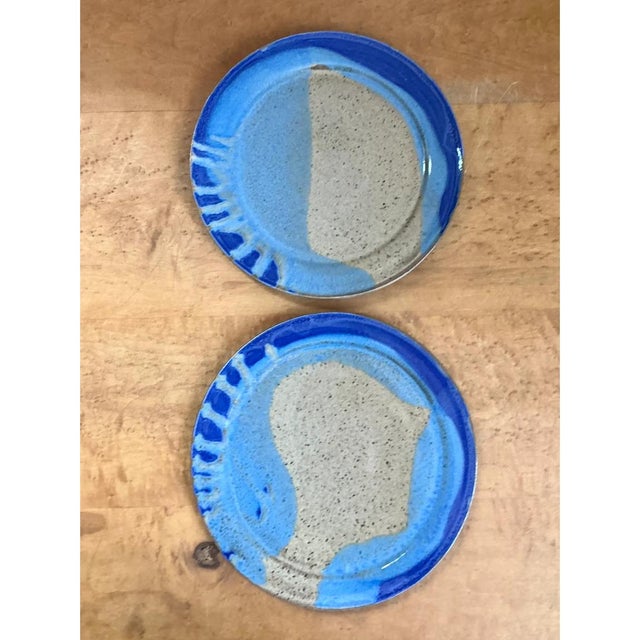 This pair of vintage stoneware plates showcases a bold, hand-glazed abstract composition in layered tones of blue. Each...