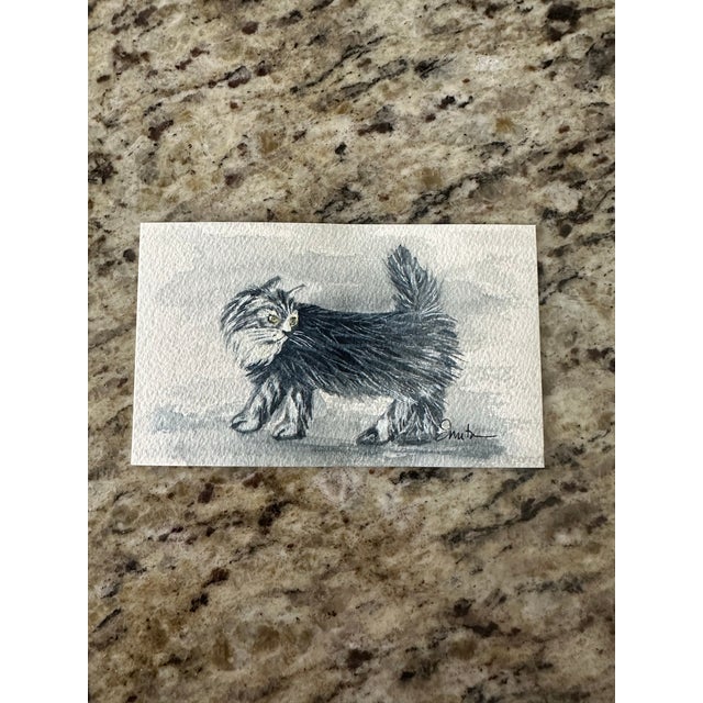 This elegant monochromatic watercolor captures the quiet confidence of a long-haired cat mid-stride. With dramatic fur...