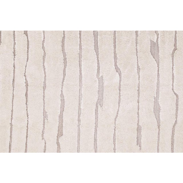 Elegant and timeless, this hand-knotted wool rug in Ivory is accented with a subtle organic Light Taupe line pattern that...