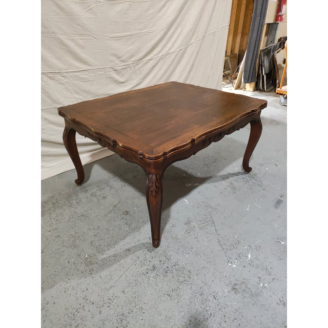 This elegant French Provincial dining table features classic Louis XV styling with graceful cabriole legs, carved foliate...