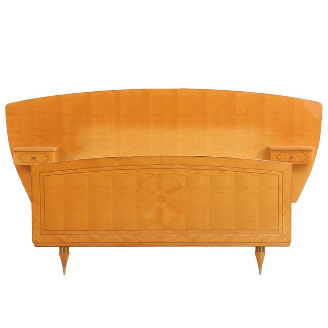 An elegant French full-size bed crafted in beautifully figured sycamore and mahogany, dating to circa 1950 and...