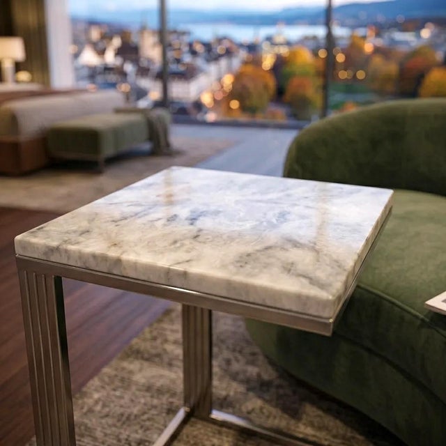This minimalist side table features a polished white marble top with subtle grey veining, offering a crisp and timeless...