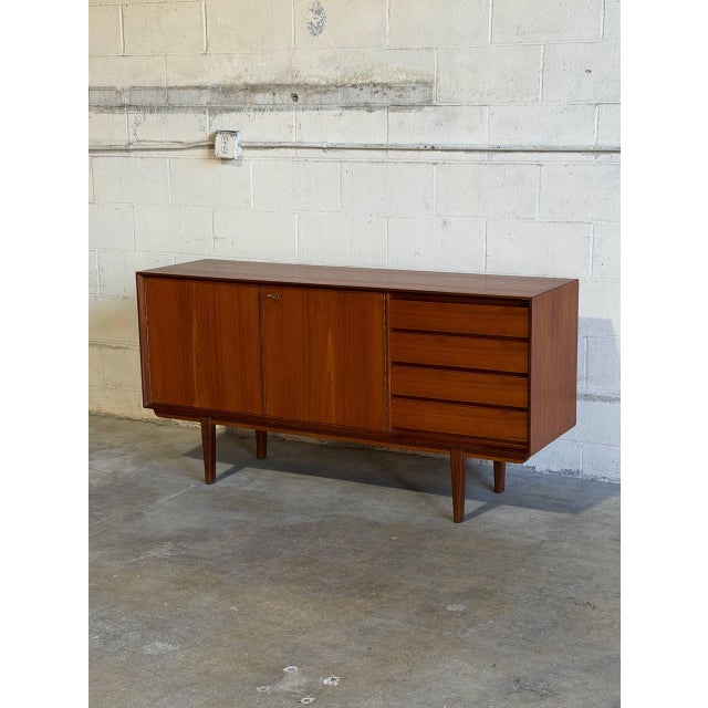 This minimalist sideboard combines clean lines with functional Scandinavian design heritage. The left side features a...