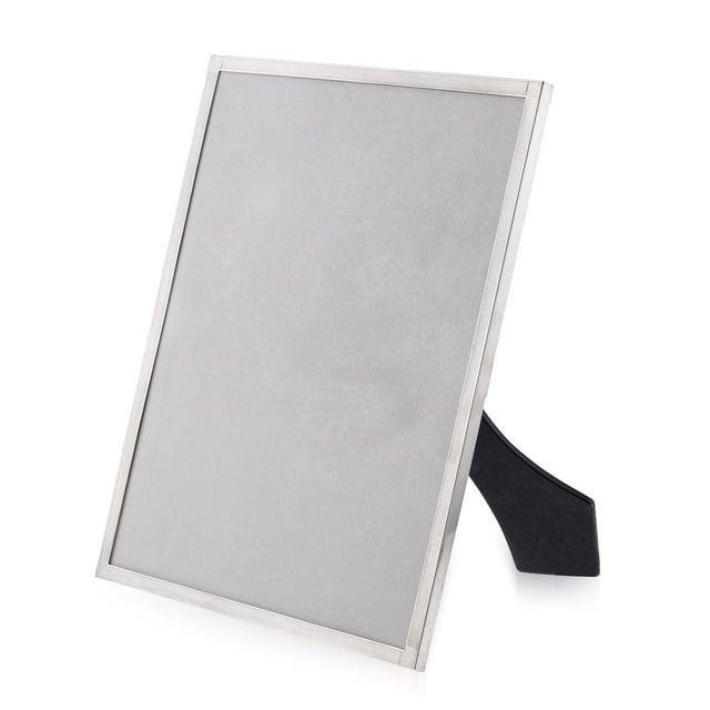 20th Century Art Deco silver & engine turned photograph frame, with stylized corners, mounted on an ebonised easel support...