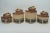 A set of four interlocking “tropical and mountainous landscape” pottery jars having weaved wicker lid handles. All signed...