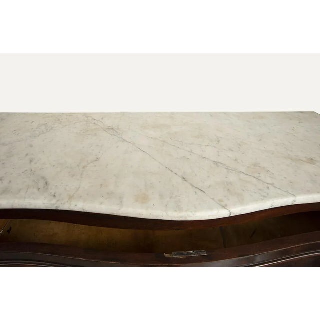 : Bagn Filippo Neapolitan Filipo in mahogany feather with Carrara white marble top. The curvilinear front is characterized...