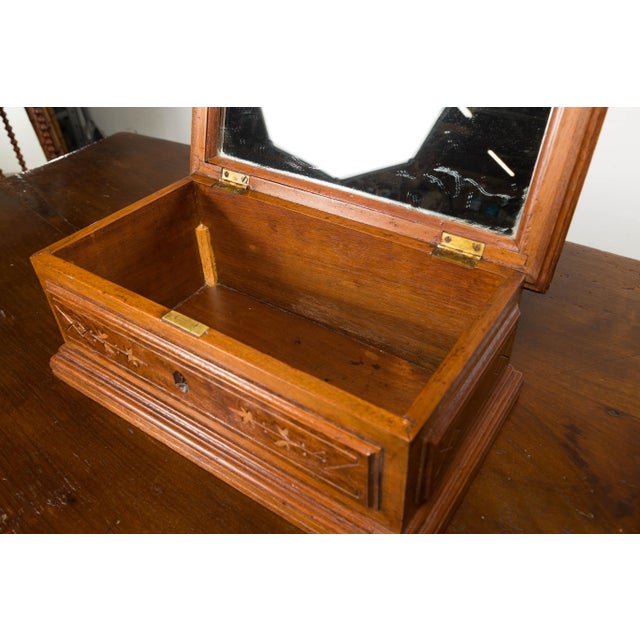 An English oak decorative box from the 19th century with carved dog on the lid, stylized foliage on the front and...