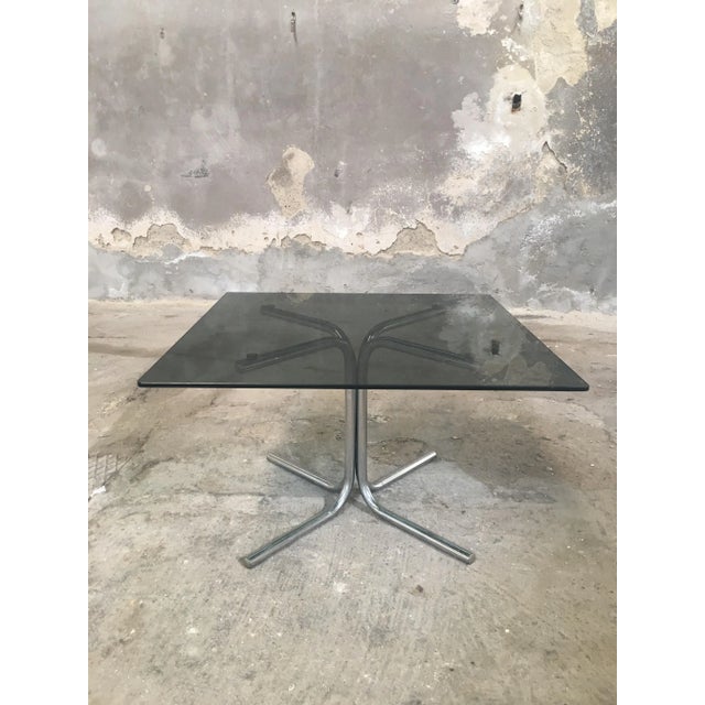 This coffee table with chromed base and glass top was made in Italy during the 1970s.