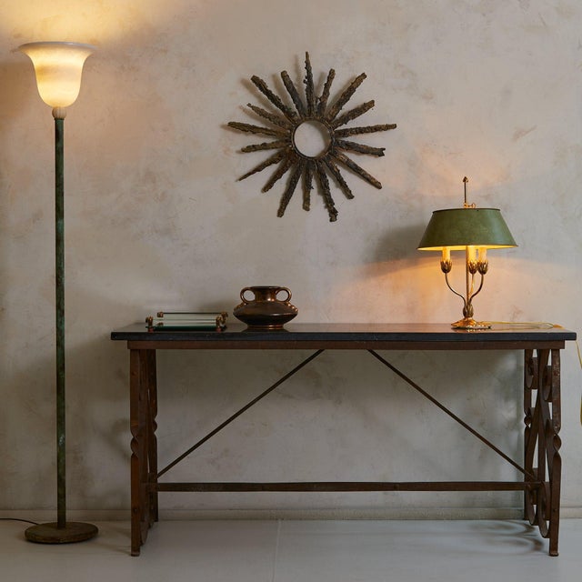 A quiet relic of 1940s France, this console table bridges the industrial and the ornate. Its cast iron frame, rich with...