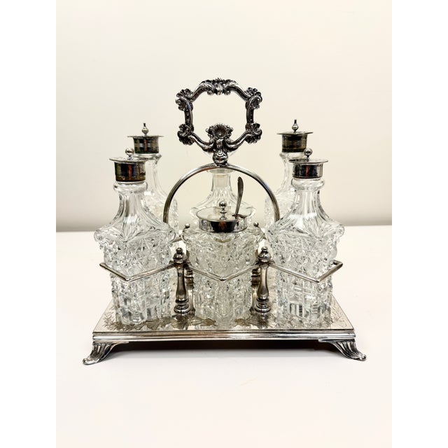 A beautiful antique or vintage condiment set featuring cut crystal or glass bottles housed in an elegant silver-plated...