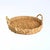 Vintage round hand-woven seagrass tray featuring a tightly woven natural fiber construction with warm organic texture and...