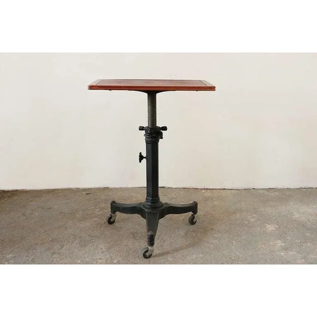 An adjustable antique table designed for an optometrist's office. Walnut tabletop with a vinyl inlay set on a steel base...