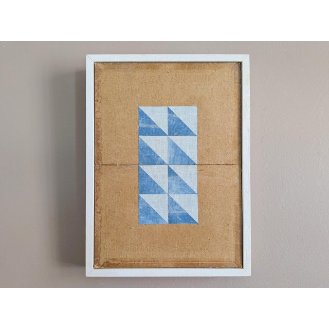 GEOMETRIC COLLAGE IN BLUE TRIANGLES Size: 11.8 x 8.9 inches (including frame) Repurposed book binding materials on wooden...