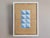 GEOMETRIC COLLAGE IN BLUE TRIANGLES Size: 11.8 x 8.9 inches (including frame) Repurposed book binding materials on wooden...