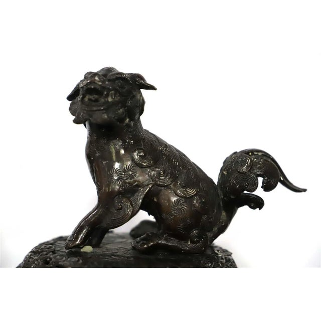 Antique Chinese cast bronze censer or incense burner has a cover with a temple lion or Foo Dog sculpture handle, 19th c....