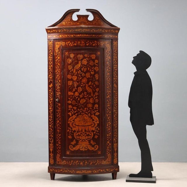 Dutch mahogany corner cabinet. Arched front with a single door, maple fillets and inlays throughout depicting intertwined...