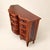 A Maitland-Smith commode in richly figured flame mahogany, its bowfront center bank flanked by two curved columns of...