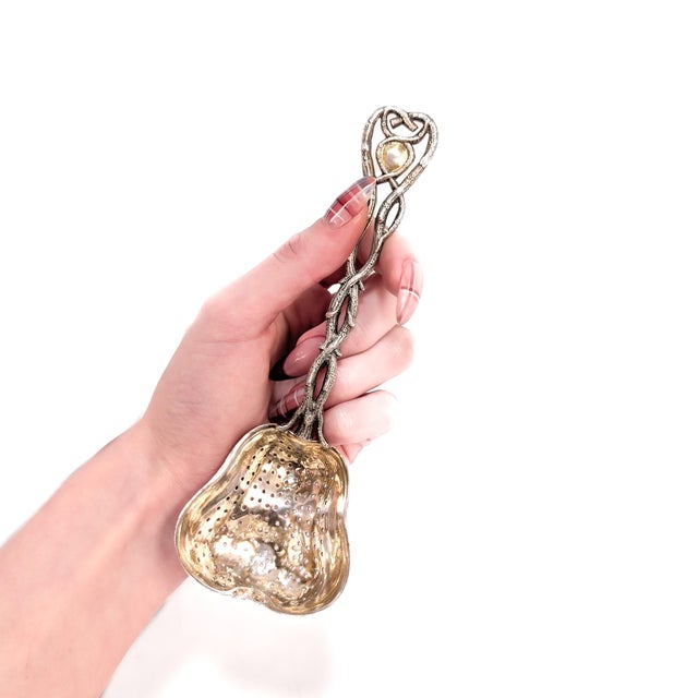 A fine mid-19th century Russian tea strainer. In 84 Zolotnik silver. By Carl Gustav Ekqvist of St. Petersburg. The figural...