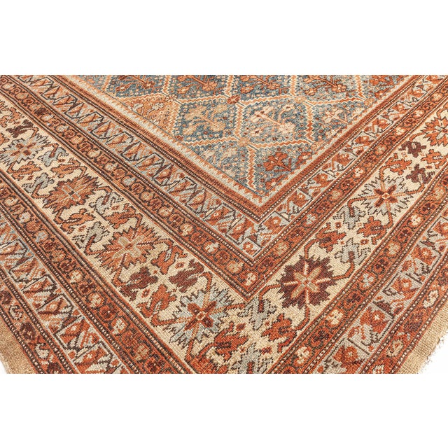 An Early 20th Century Persian Malayer garden carpet on an abrashed, faded blue field with lozenge trellis boxes and inside...