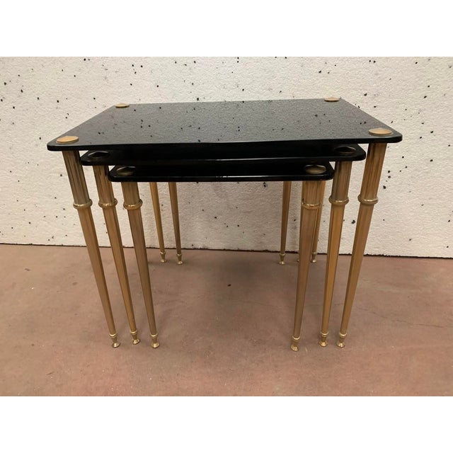 Set of three nesting tables Gilt brass base Black smoked glass top Good condition Dimensions: H 45 x W 53 x D 35 cm 20th...