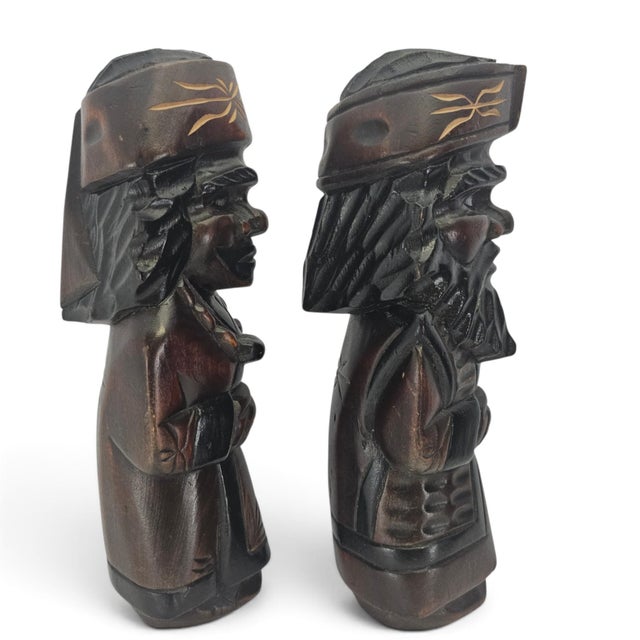 A matched pair of mid-century Japanese Ainu folk figures, hand carved in Hokkaidō and depicting a man and woman in...