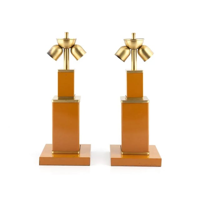 Pareja de lámparas de mesa italianas de la década de 1970, realizadas en metal lacado en color ocre con elegantes detalles...